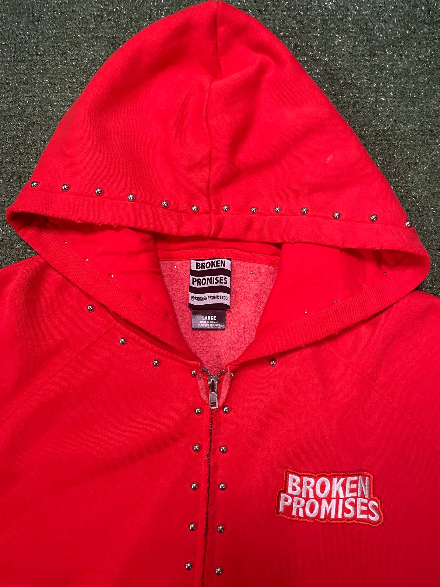 Broken Promises adorned red zip up hoodie